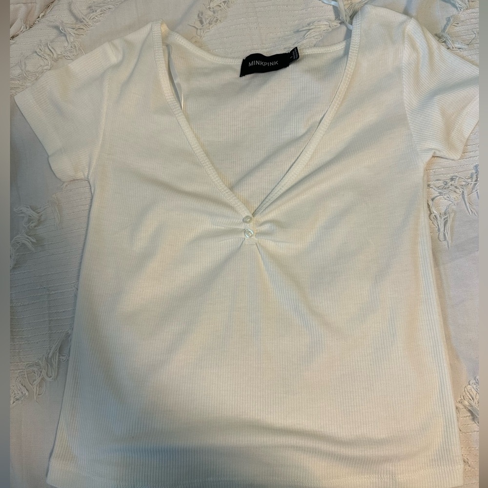 White V-neck tee. Minkpink size small. Two buttons at the bottom of the V.